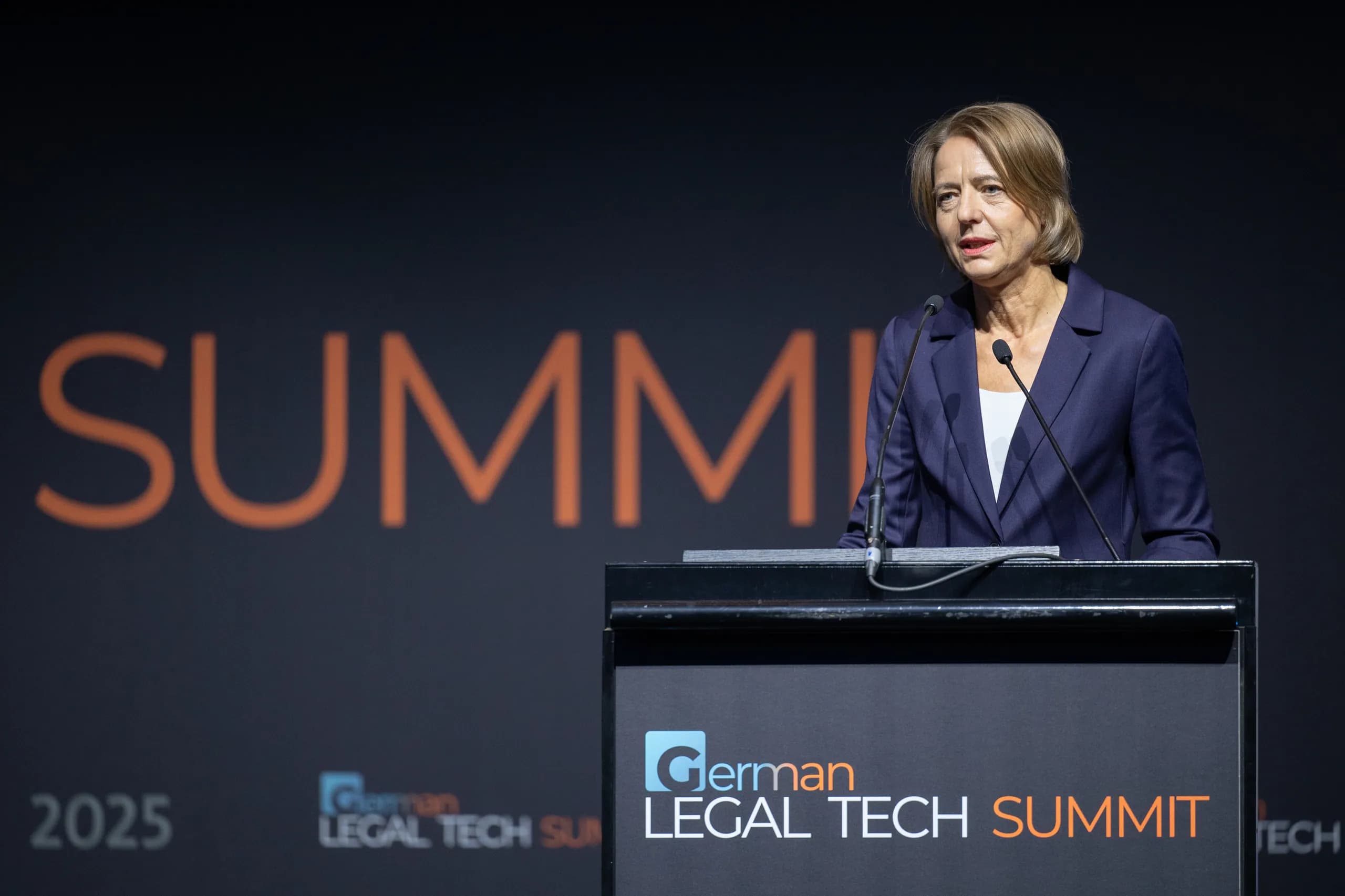 A speaker at the lectern in front of the Summit lettering
